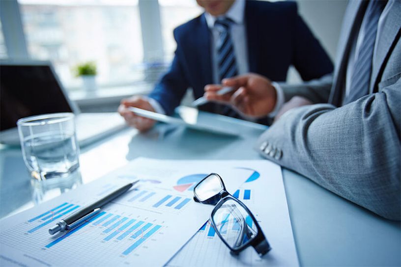 Financial professionals discussing and reviewing documents.