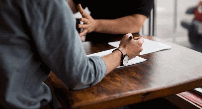 Two employees discussing and reviewing documents.