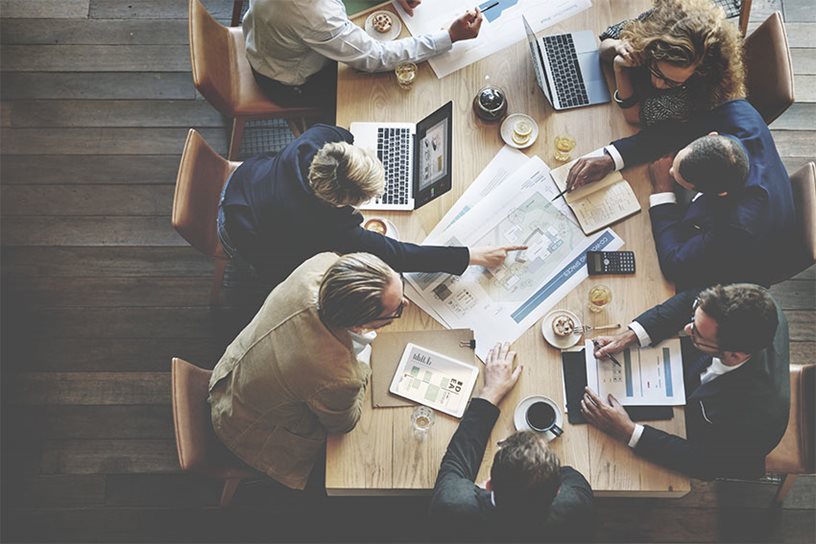 A-M9.jpg An aerial view of office workers collaborating around a table.